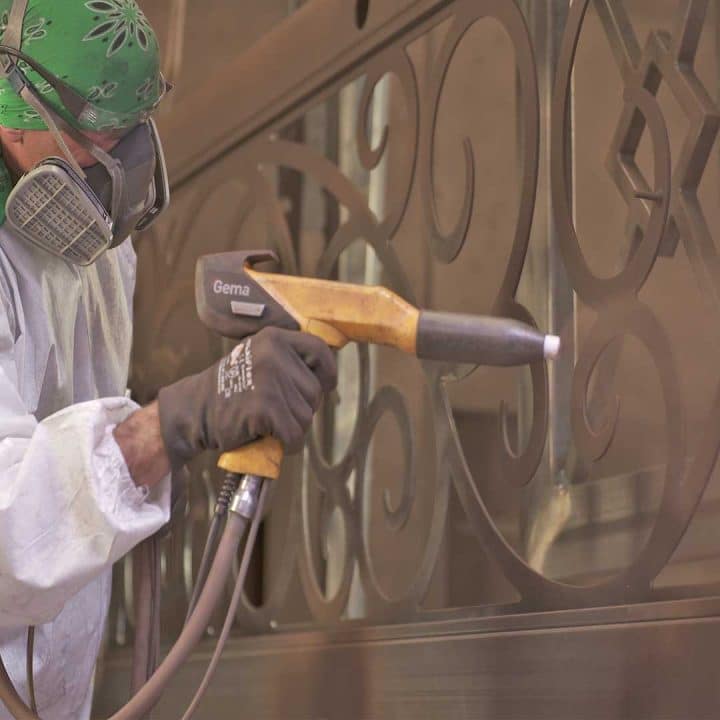 First Impression Ironworks team member powder coating a custom Iron Entry door.