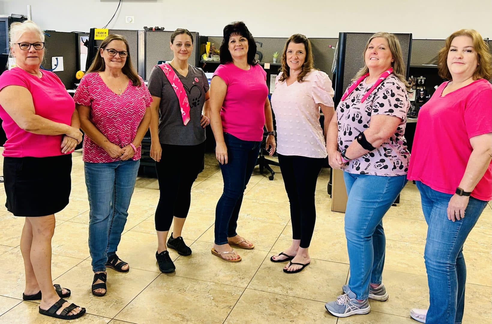 Group of women dressed in pink, who are First Impression Ironworks employees