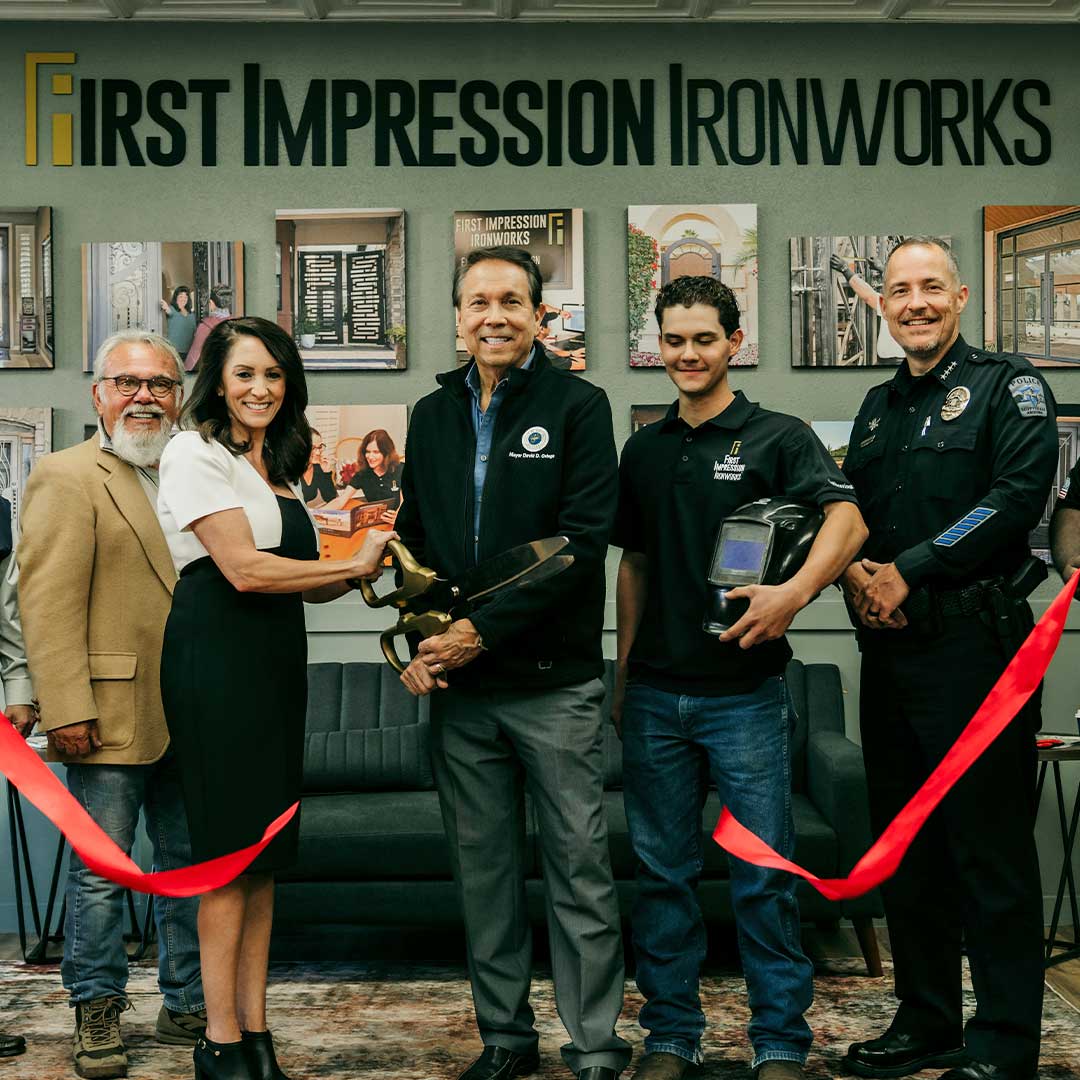 Members of the First Impression Ironworks Team and members of the community, cutting the ribbon, at the grand opening of the new Scottsdale Showroom.