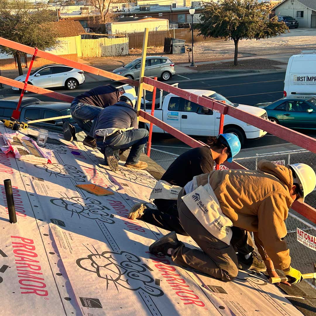 Several men working on the roof of a house being built