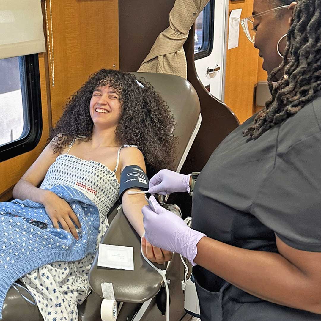 A smiling First Impression Ironworks employee donating blood