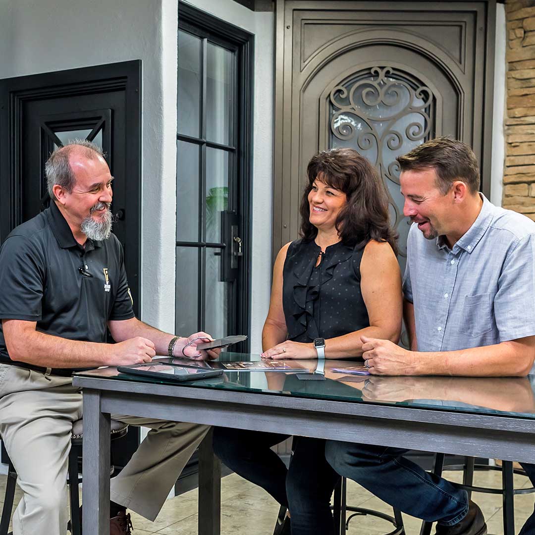 Homeowners sitting with a First Impression Ironworks Design Specialist inside a First Impression Ironworks showroom.