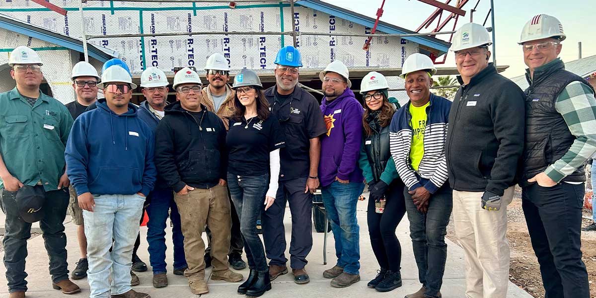 Large group of First Impression Ironworks team members posing for a picture while volunteering with Habitat for Humanity