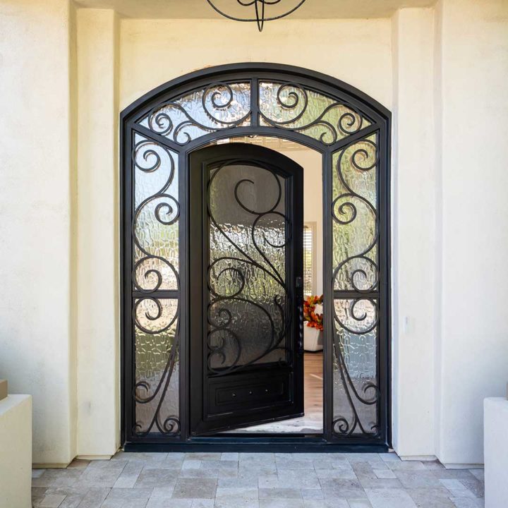 Large custom iron entry door with glass sidelights